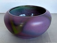 Side view of iridescent purple and green Bretby bowl
