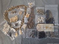 Overview of entire lot showing necklaces, multiple bags of buttons, beads, findings and loose chains