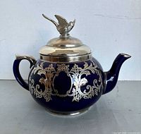 right side view of cobalt blue teapot with silver overlay and lid