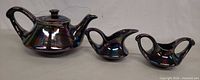 Side view of teapot, creamer and sugar bowl showing iridescent glaze