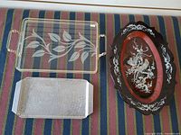 All three trays: lucite with leaf etch, hammered metal, lacquer with inlay