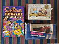 Front view of all three items: graphic novel, board game, RC car in box
