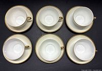 Six cup and saucer pairs laid out flat facing top view