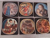 All six decorative plates in boxes displayed together