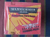 Front of sealed booster box showing Warhammer 40,000 branding and Battle for Pandora Prime graphic