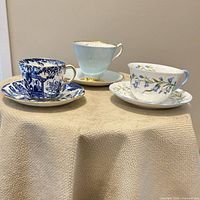 All three teacup and saucer sets displayed together on table