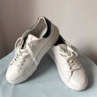 Full pair of white leather GEOX sneakers, side and toe view