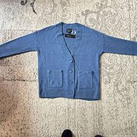 Front view of blue cashmere cardigan laid flat