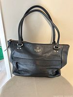 Full view of black Kate Spade leather handbag showing overall style and handles