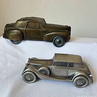 Both metal car banks side-by-side showing scale and finishes