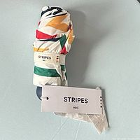 Umbrella folded with hang tag and sleeve showing STRIPES HBC branding