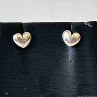front view of heart stud earrings on black background