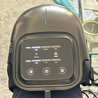 Front view showing control panel with heat and vibration settings, USB cable attached