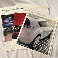 All three Saab publications overlapped; frontmost cover shows Saab 9-X BioHybrid concept