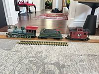 Full view of locomotive, tender, caboose, track and boards
