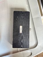 closed black wood case with ICS plaque