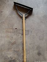 Full view of Ames dethatching rake showing wood handle and black metal head