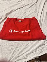 Folded red Champion crewneck showing front logo