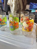 Five Camp Snoopy glasses grouped together showing different scenes and base text