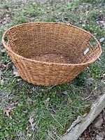 Full view of oval wicker basket on grass