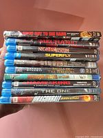 Stack of 10 Blu-ray movie cases showing spines with titles