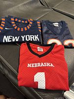 Three folded jerseys showing front designs and team names