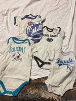All four sports team onesies laid out