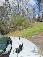 Both antennas mounted on car hood showing whip length and coiled coax