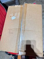 Closed cardboard box labelled copper pot holder