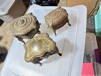 All three ornate metal jewelry boxes on plastic bin
