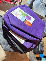 Stack showing purple and gray grow bags with retail tags