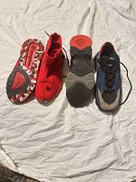 Both pairs soles up and side view showing style, color and wear