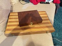 Two closed wooden backgammon cases stacked, showing size difference