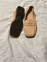 Sole view and side profile of one loafer with tread pattern visible