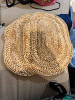 Stack of natural braided-straw chargers showing material, weave and condition