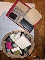 Top view showing wicker basket filled with assorted boxes and adjacent red tray holding additional boxes