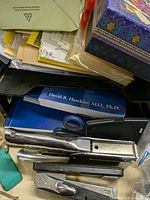 Close-up of staplers, scissors, book, envelopes, tissue box and other small items