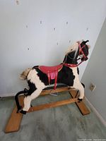 Full view of rocking horse on wooden and metal frame