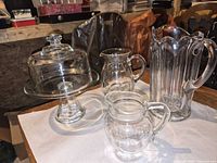 Group shot of three glass pitchers and domed cheese tray assembled