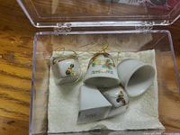Five porcelain bell ornaments in clear box