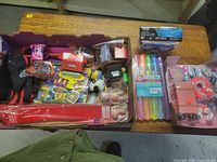 Overview of two trays filled with assorted toys, gloves and bubble wands