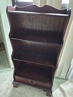 Front view showing three shelves and drawer