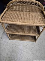Front angled view of three-tier wicker shelf showing overall structure and tiers