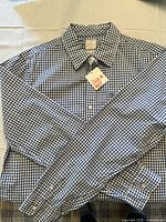 Full view of long-sleeve gingham shirt with tags attached