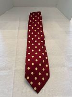 Full view of red polka dot tie laid flat