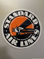 Front view of round Standard Air Lines reproduction metal sign showing full graphic and text