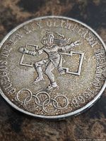 Obverse showing Aztec athlete and Olympic rings