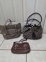 Front view of all three Michael Kors purses
