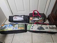 Four tent bags on floor showing brand labels and models