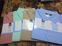 Four packaged polo shirts in various colors